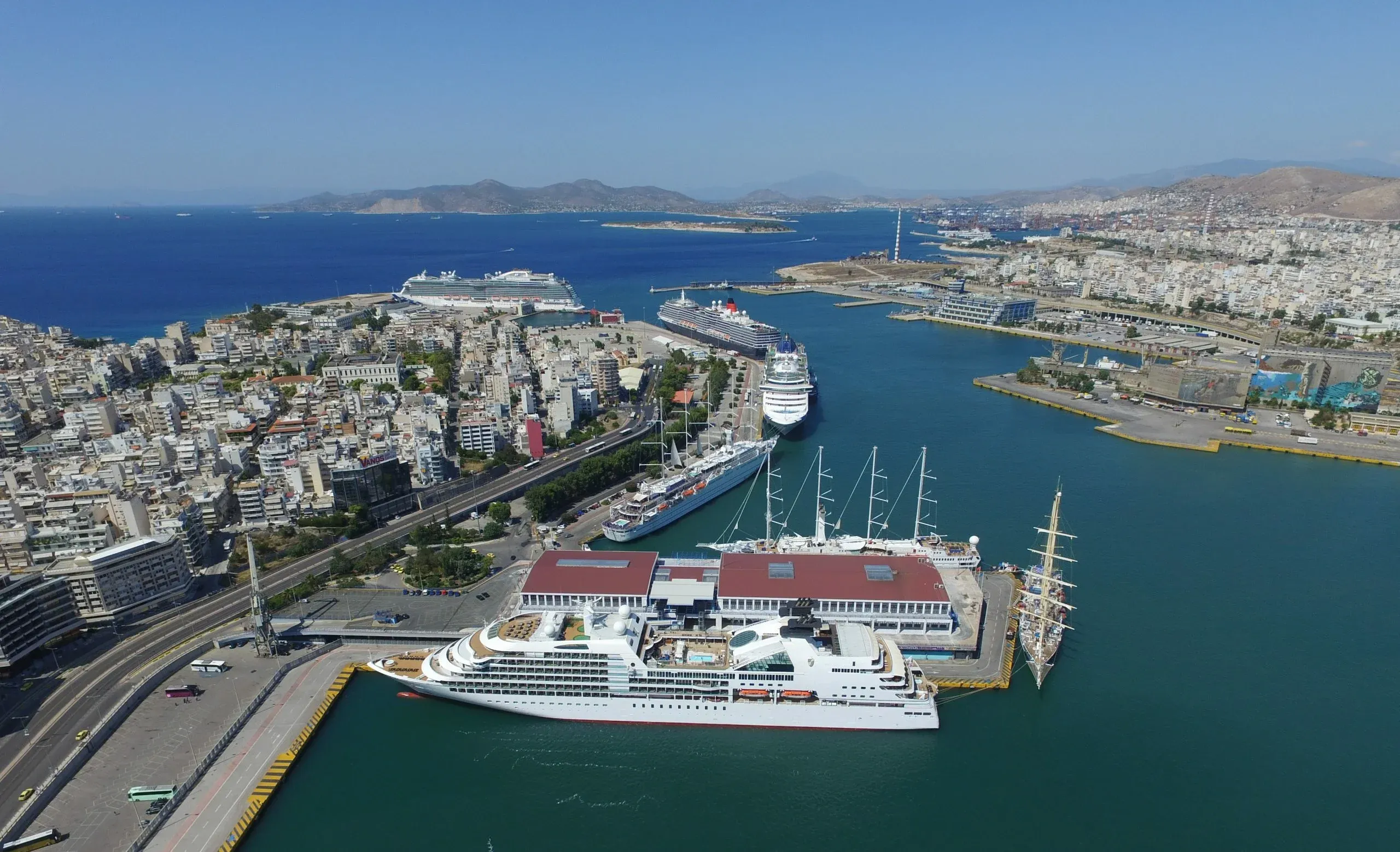 Large cruise ships docked at the busy port of Piraeus on a sunny day