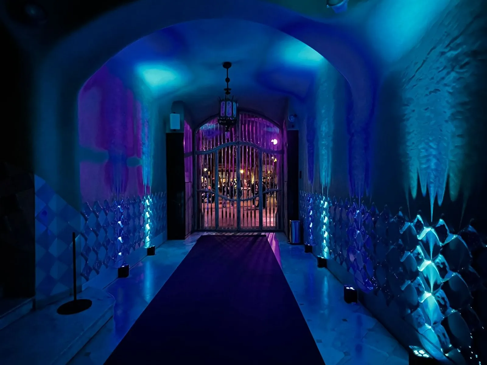 View upward inside Casa Batlló light well showing gradient blue tiles and window frames