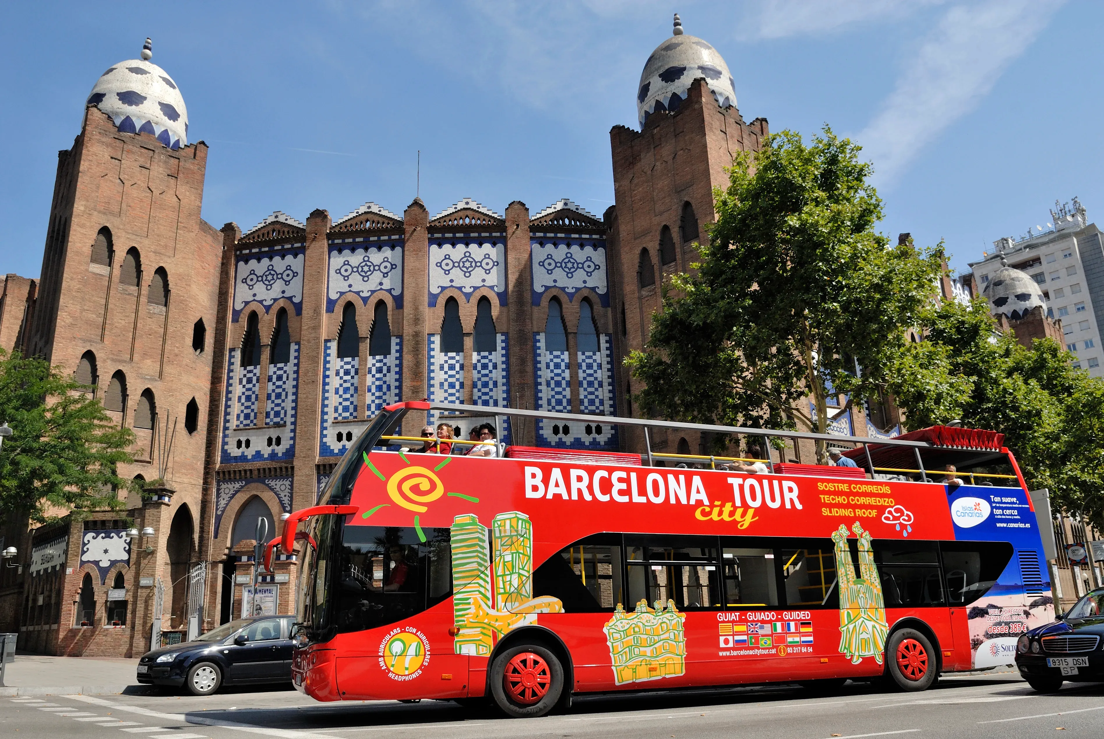 Open-top bus passing Barcelona landmarks
