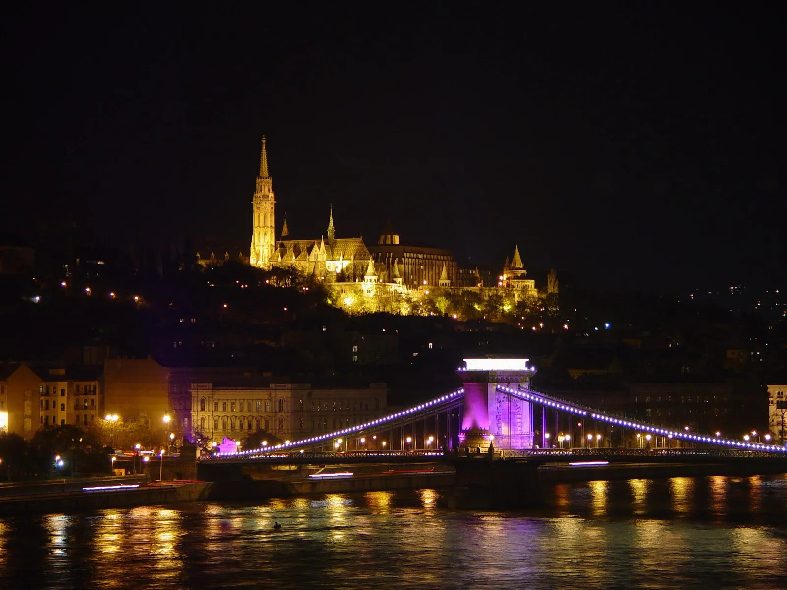 Illuminated Budapest Parliament building seen from a Danube cruise boat at night