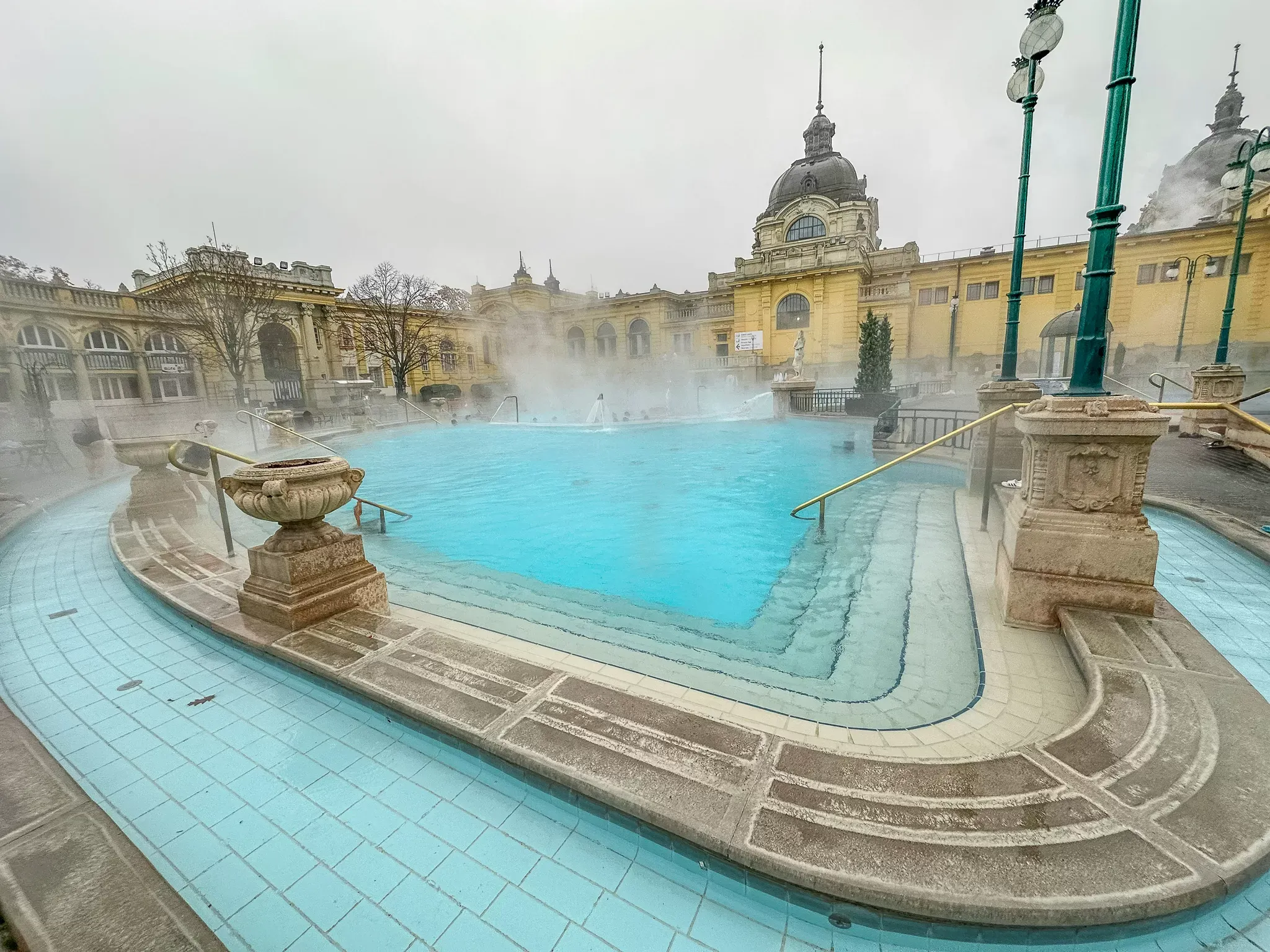 Winter mist rising from Széchenyi thermal pool surrounded by snow