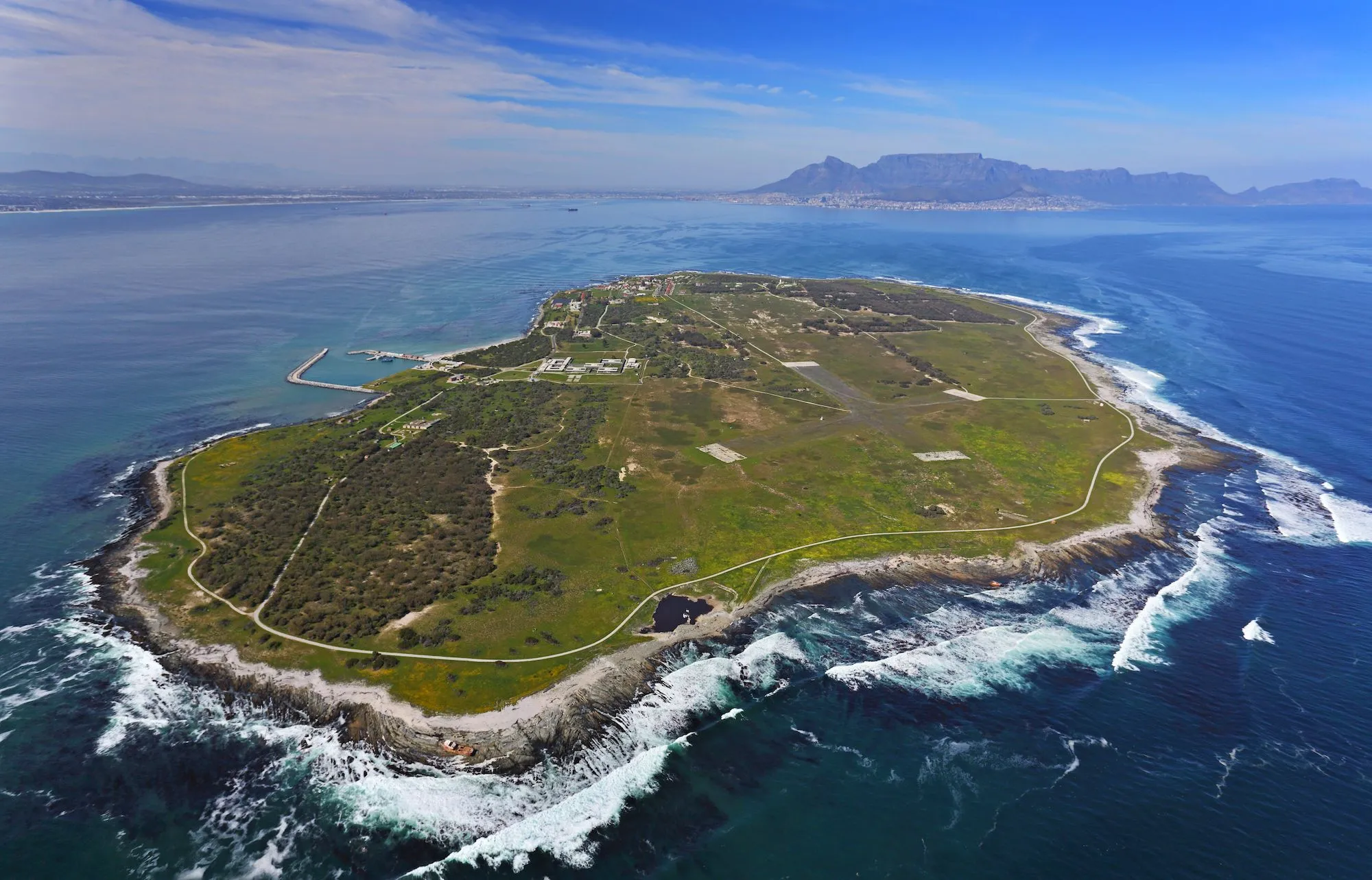 A wide view of Robben Island in Table Bay with Cape Town in the distance