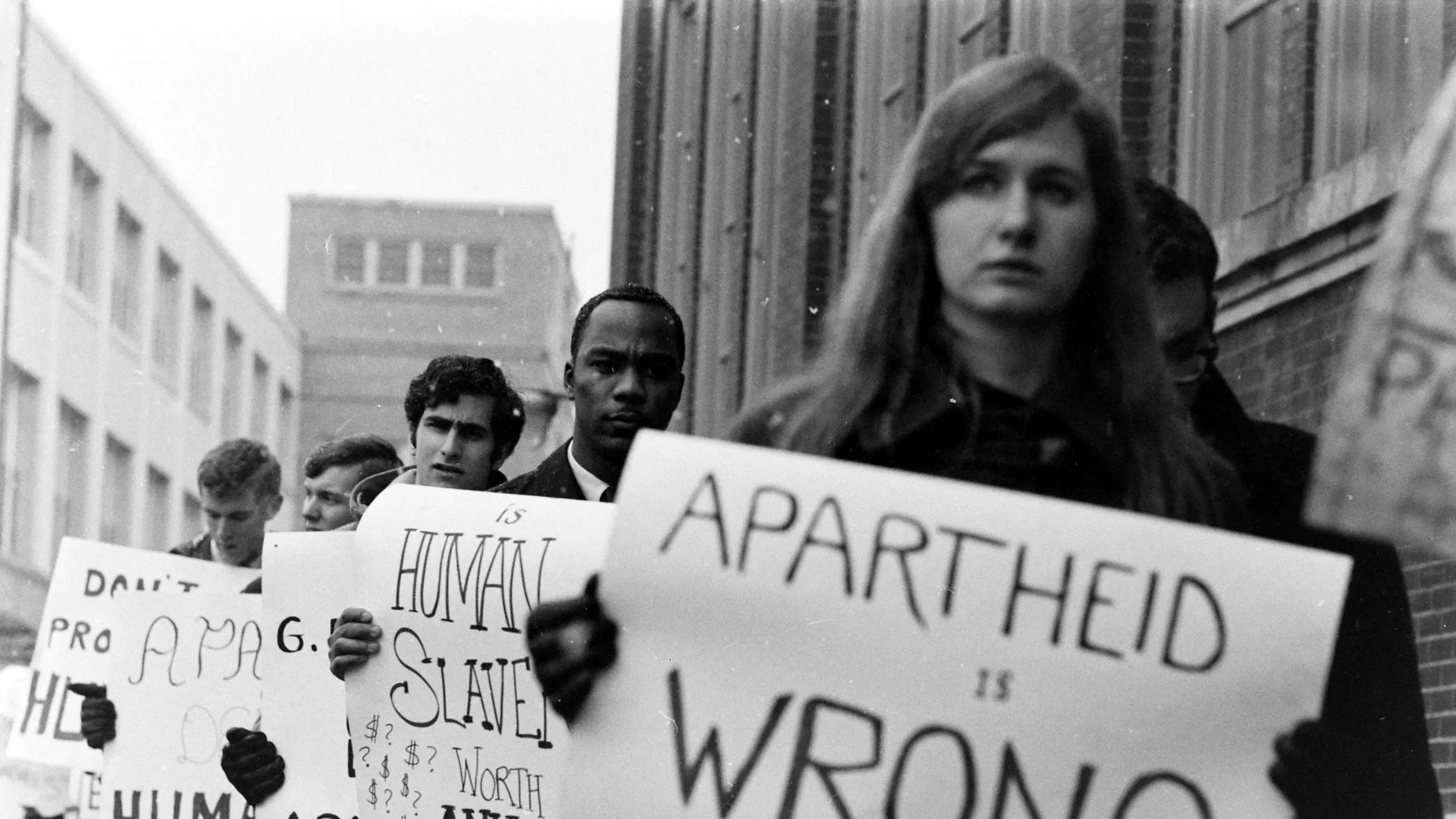 Anti-apartheid protest scene with signs and marchers