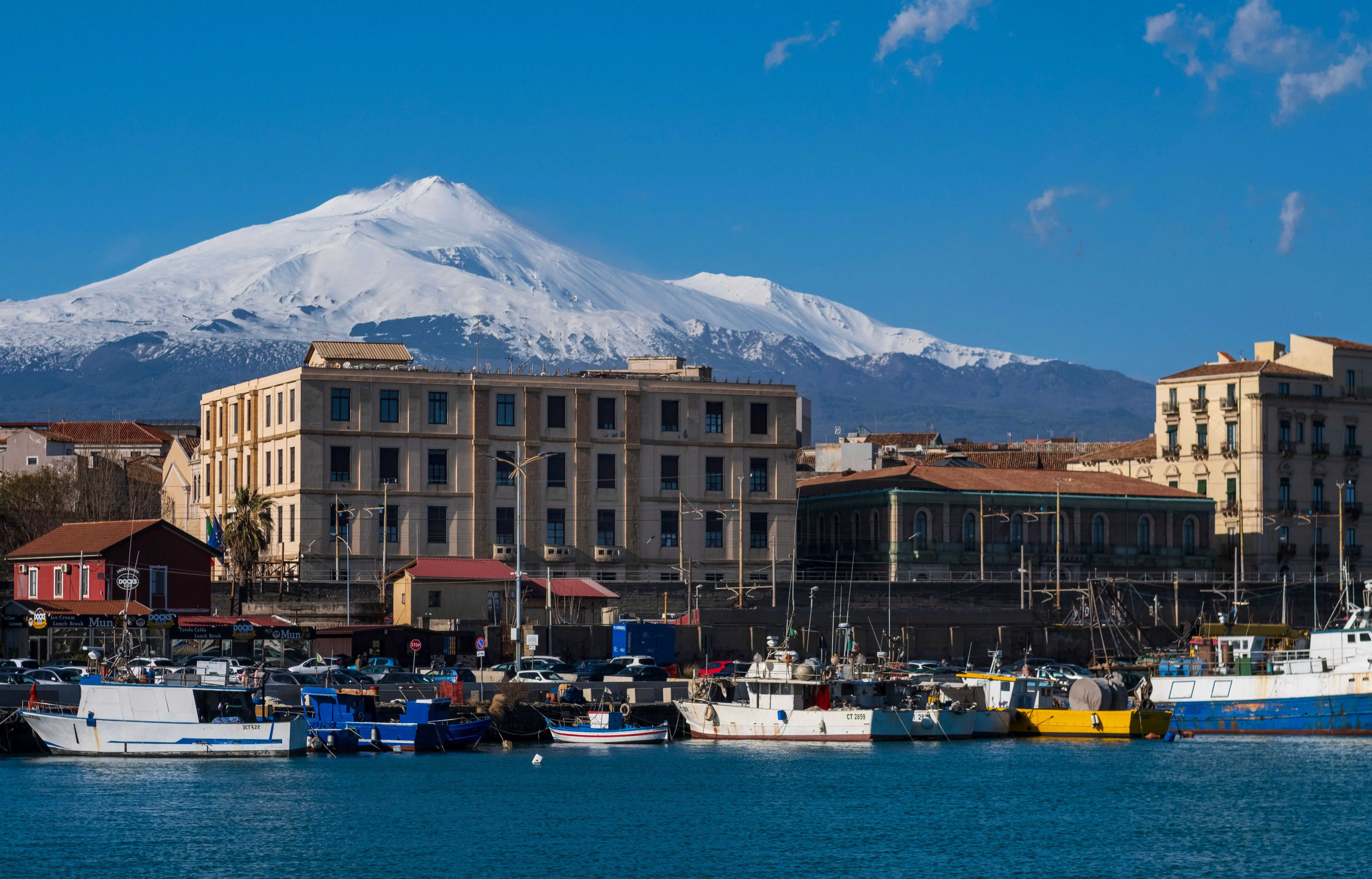 Mount Etna with snow seen from Catania harbour