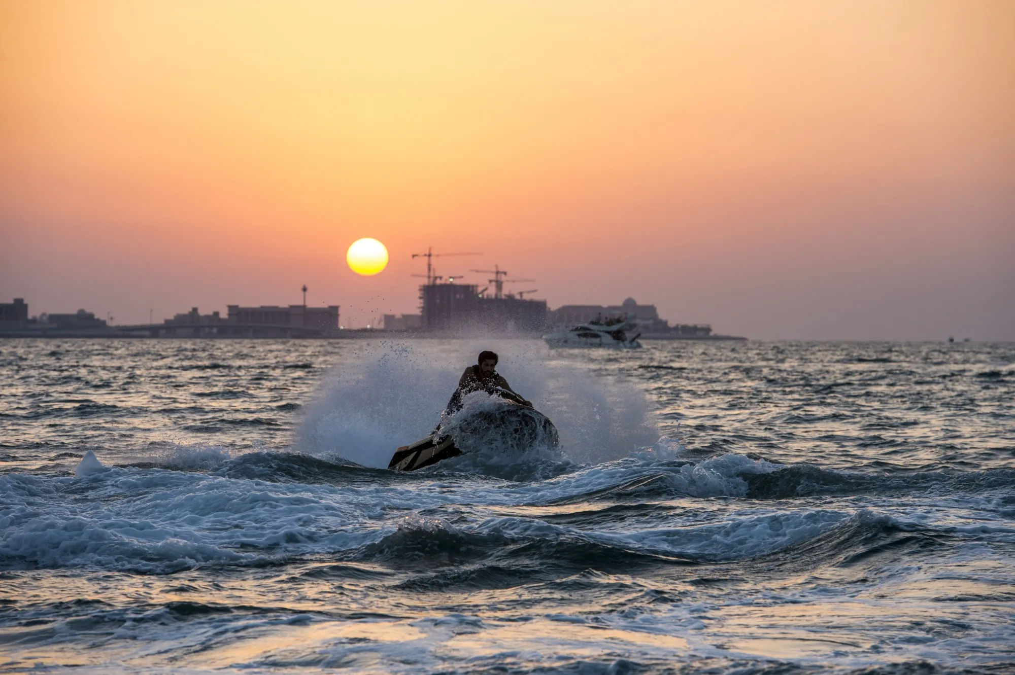 Jet ski rider at sunset with golden sky over Dubai