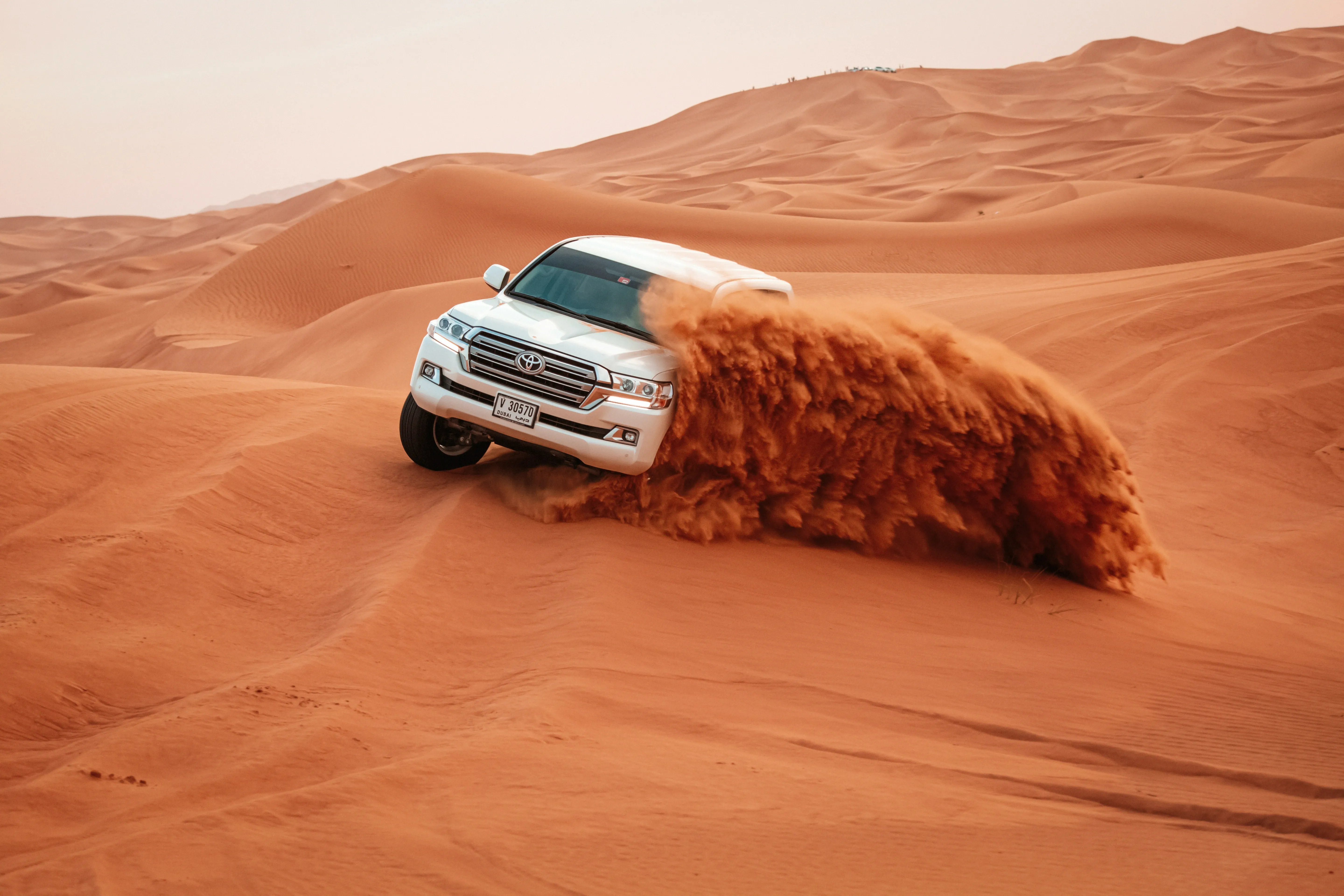Land Cruiser climbing a steep dune in Dubai