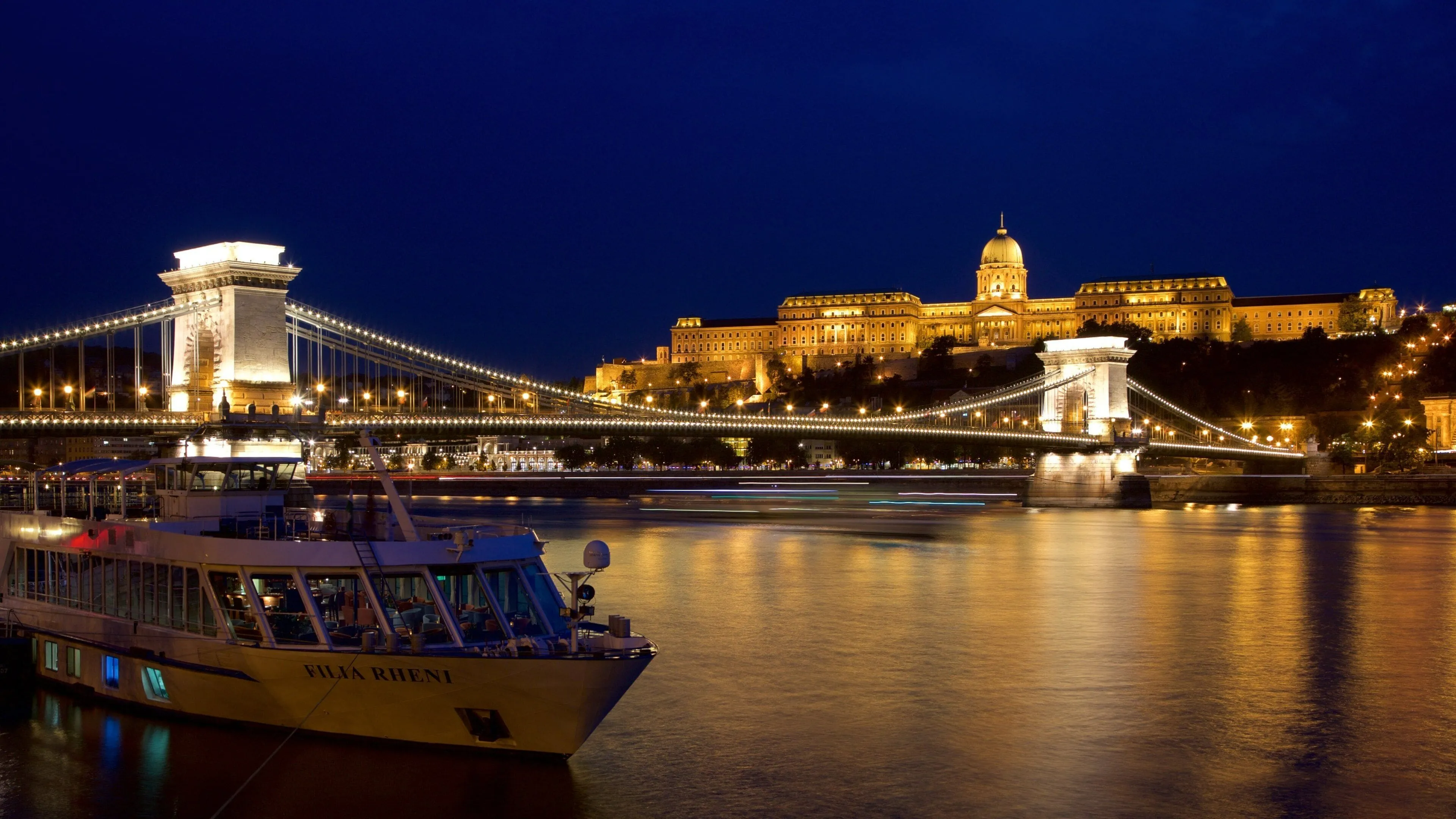 Danube cruise boat at dusk with Budapest city lights