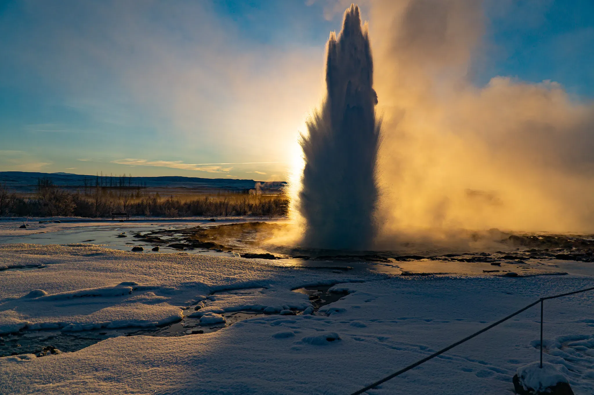 Sunset view with geyser near Secret Lagoon
