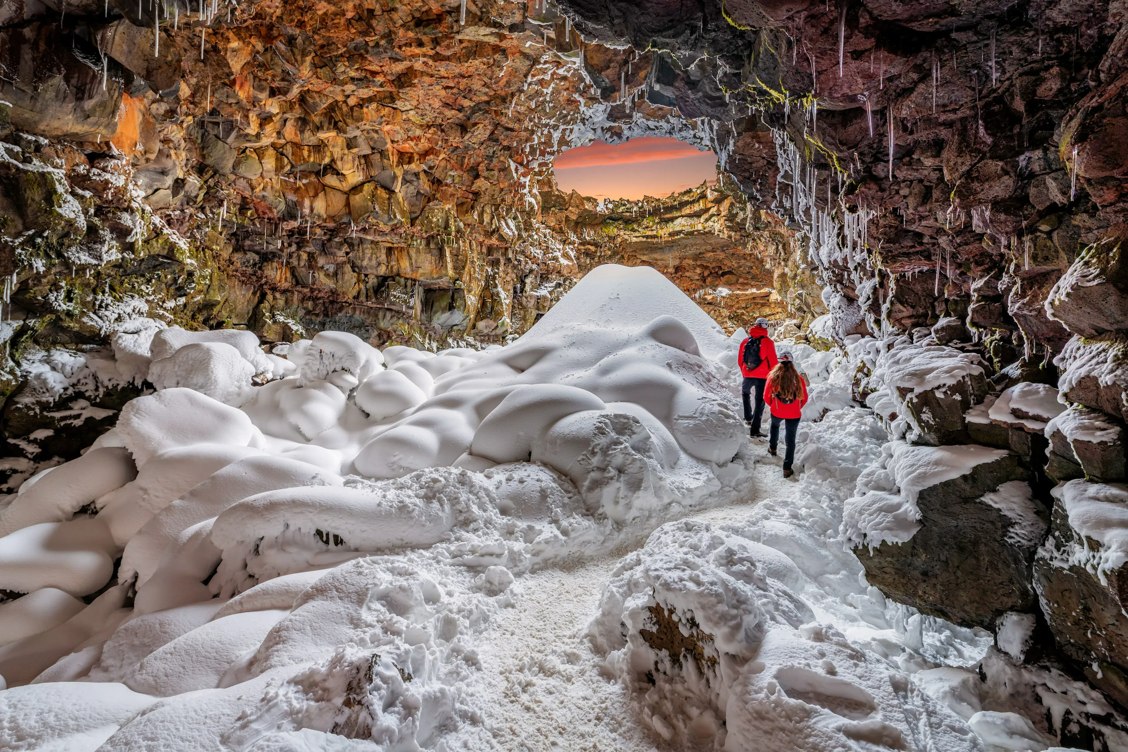 Visitors walking inside Iceland lava tunnel