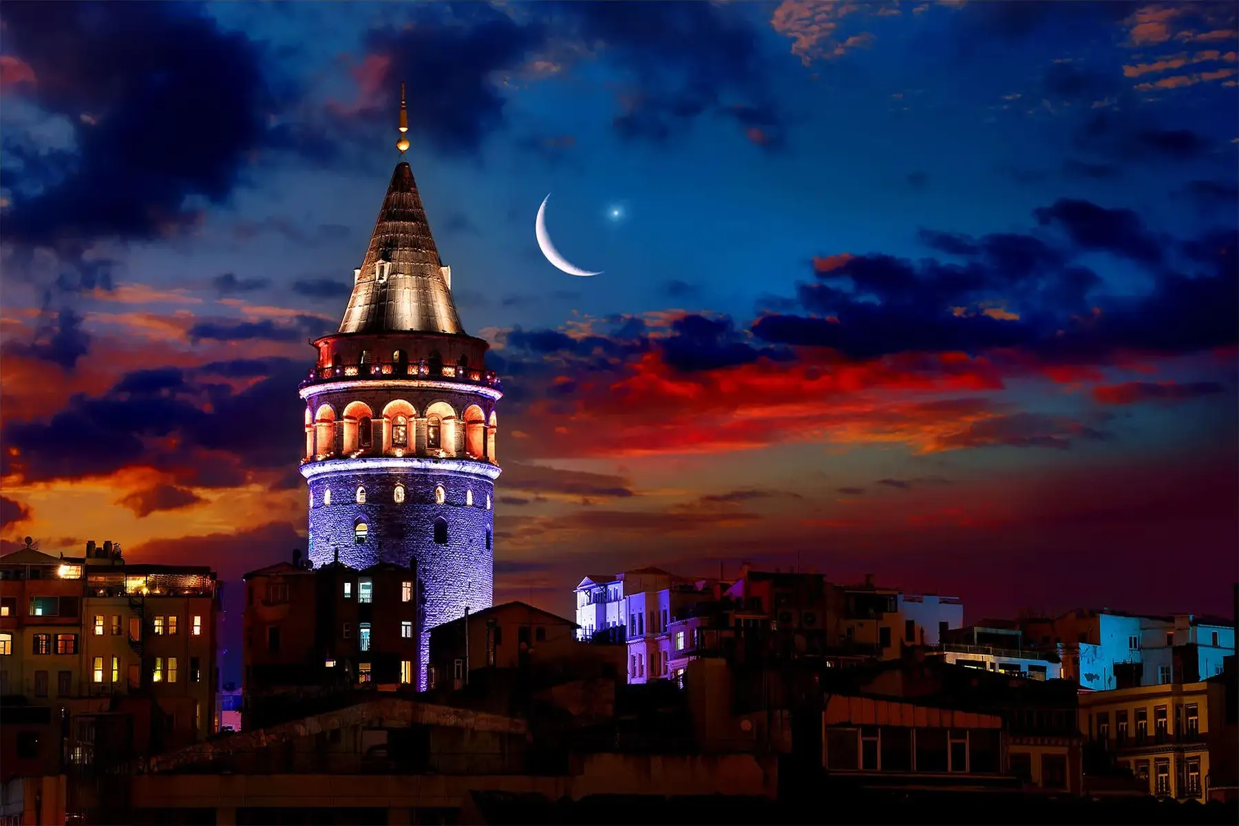 Galata Tower at night with moon and lights