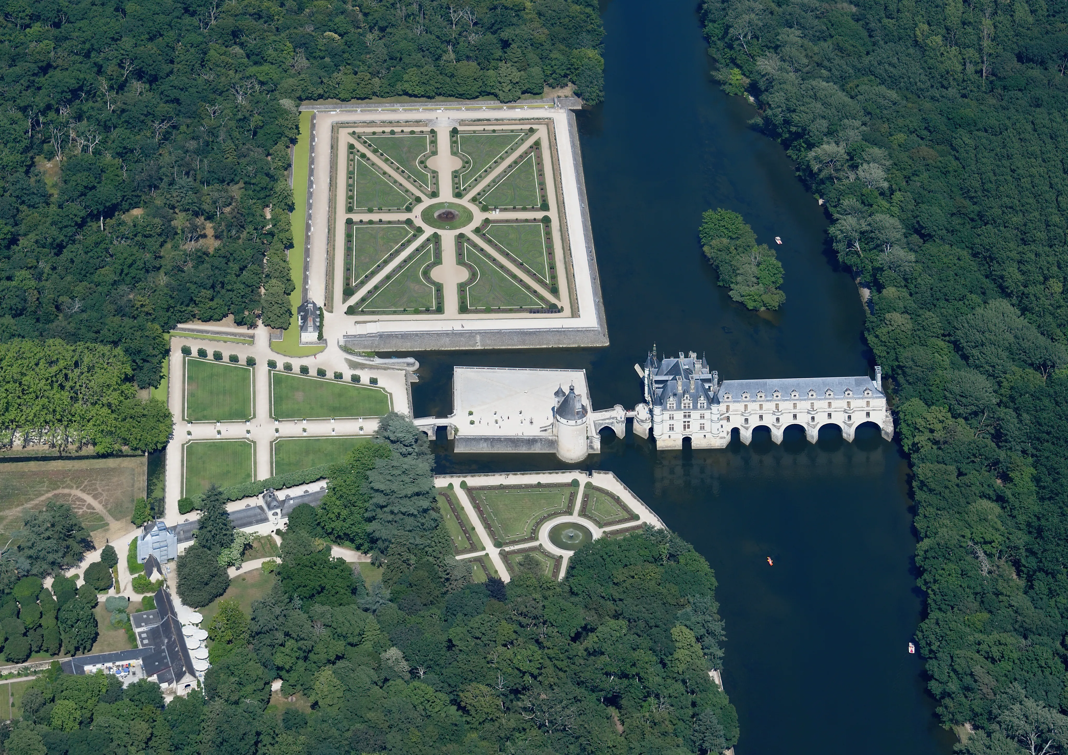 Aerial view of Chateau de Chenonceau spanning the river with formal gardens