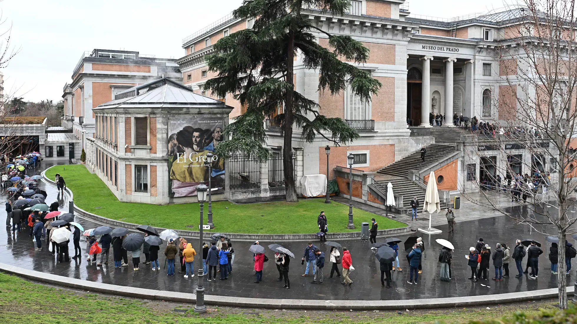 Visitors waiting in line outside Prado Museum on a rainy day