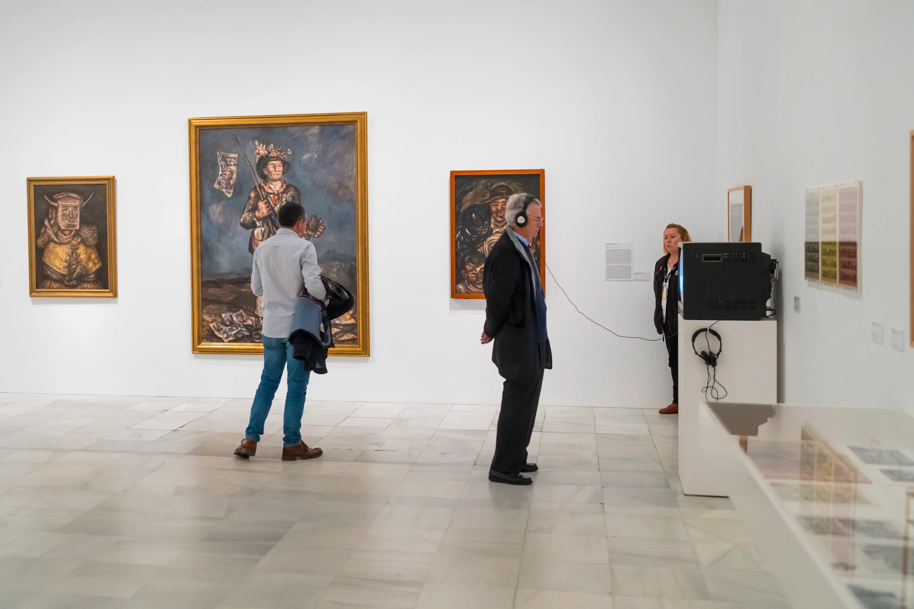 Visitors using audio guides in gallery