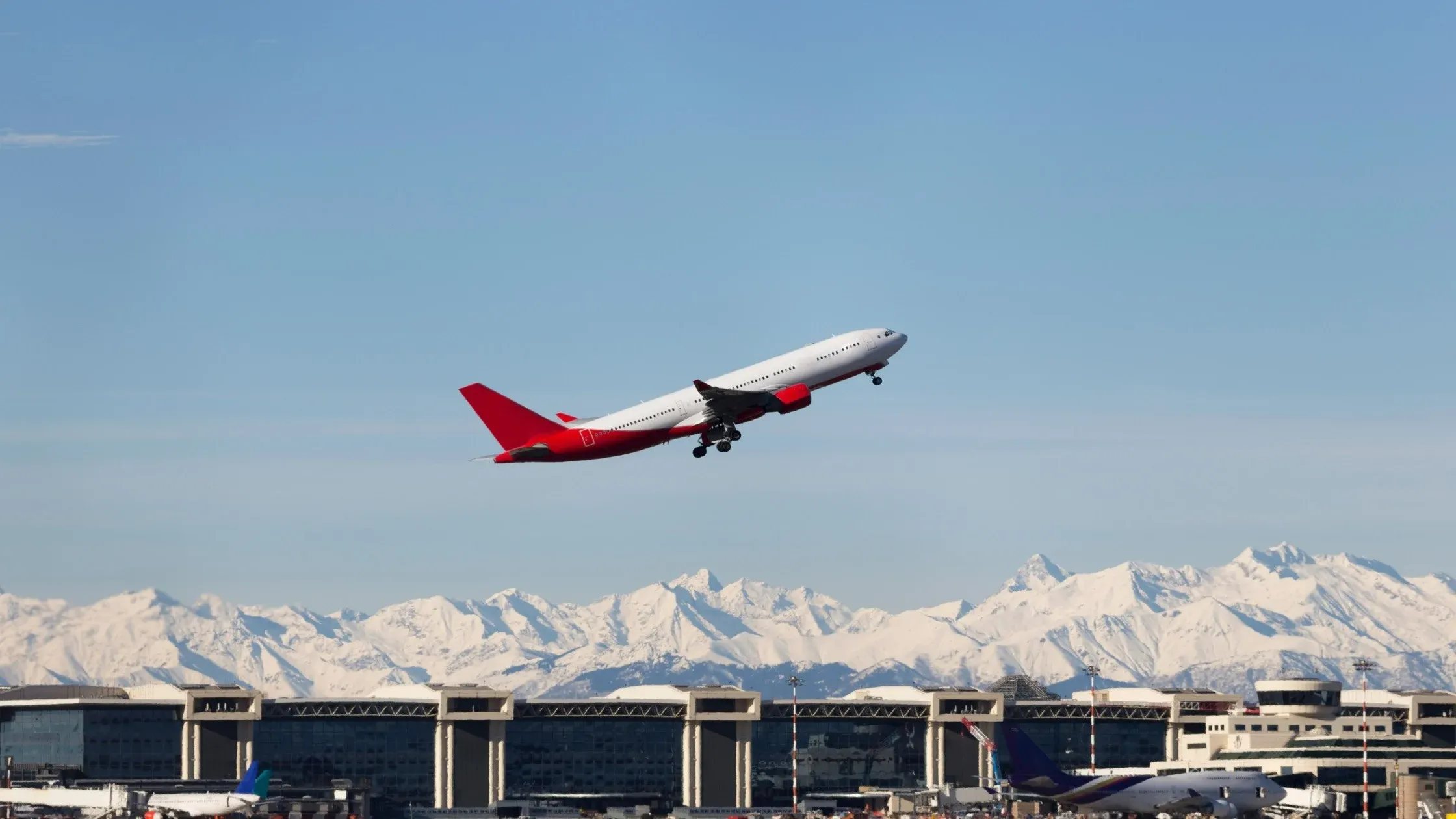 Airplane taking off near snowy Alps