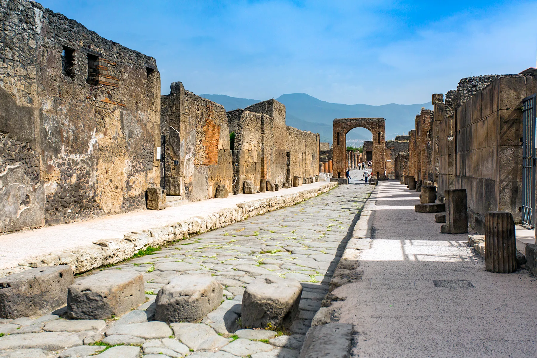 Ancient Pompeii street with Vesuvius visible in the distance