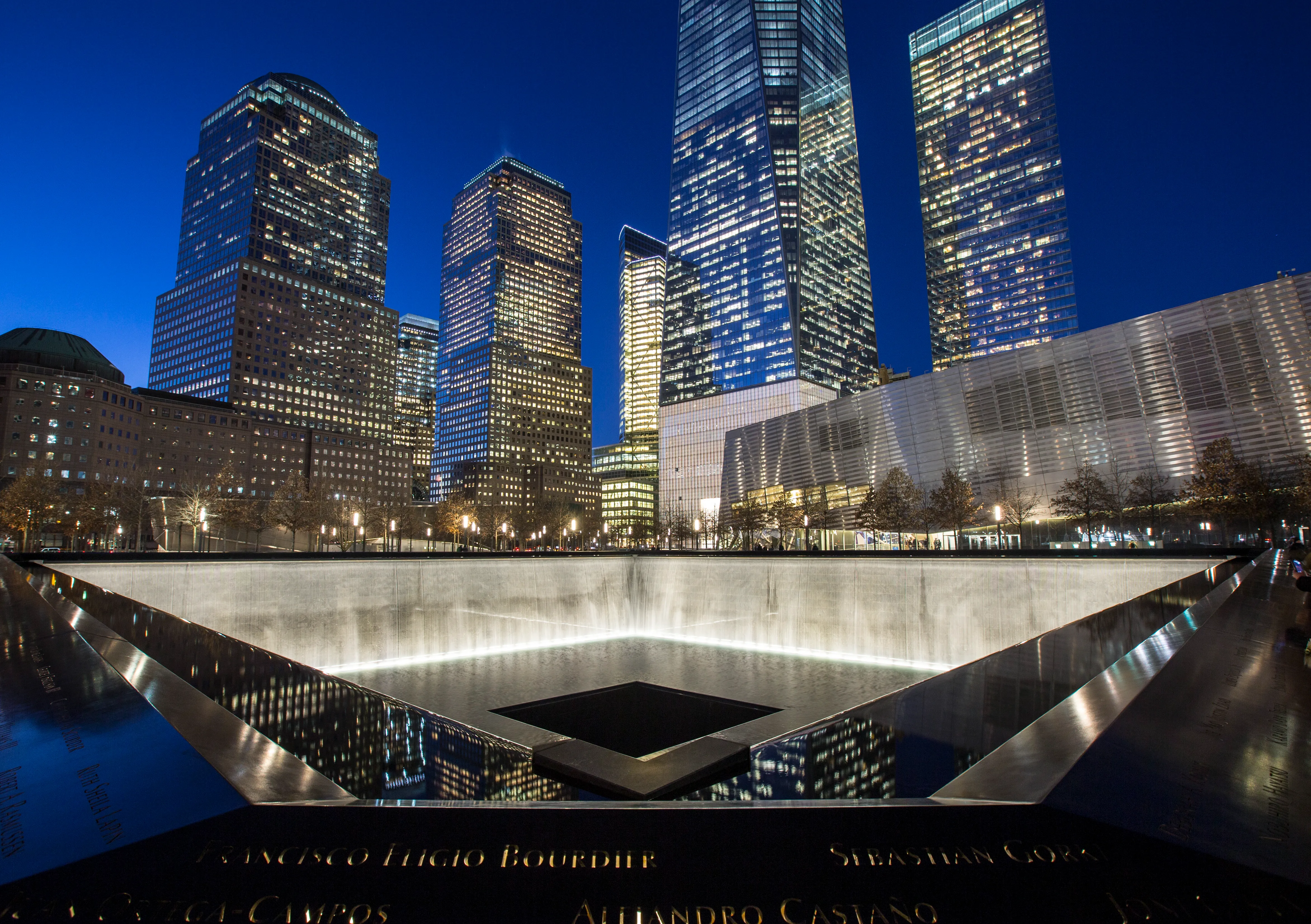 Memorial pools and skyline illuminated at night