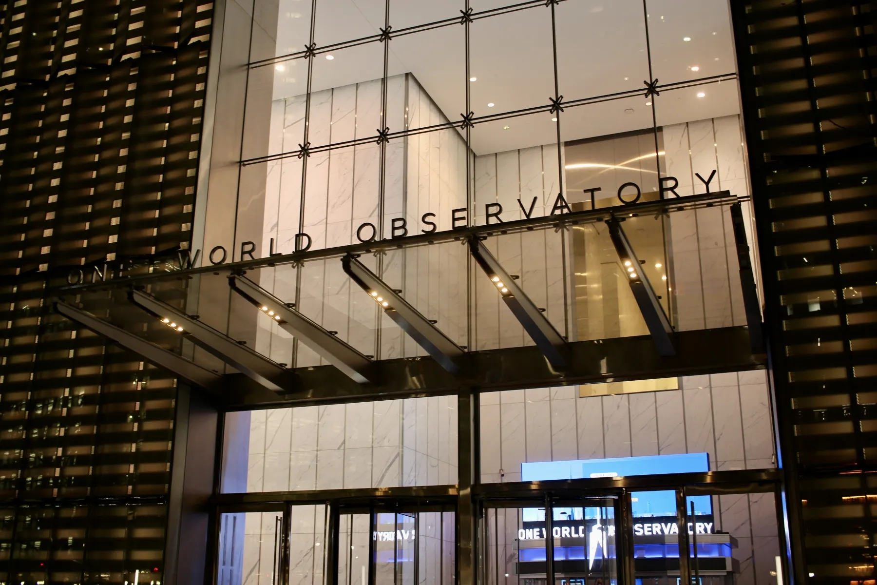 Visitors entering One World Observatory through the modern glass entrance