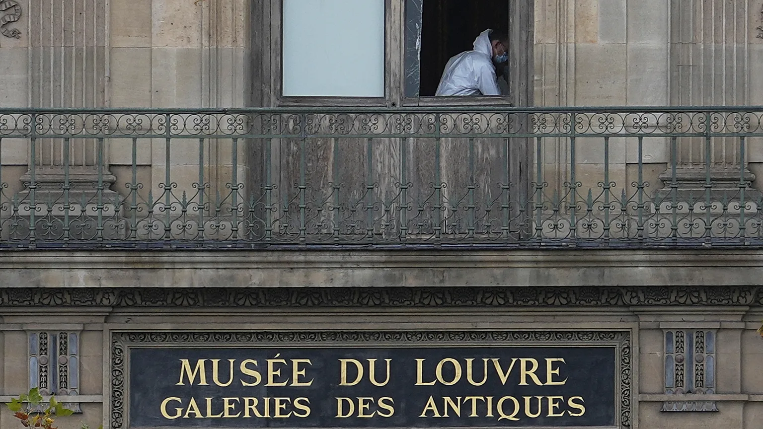 Exterior of the Louvre Museum at night with police presence