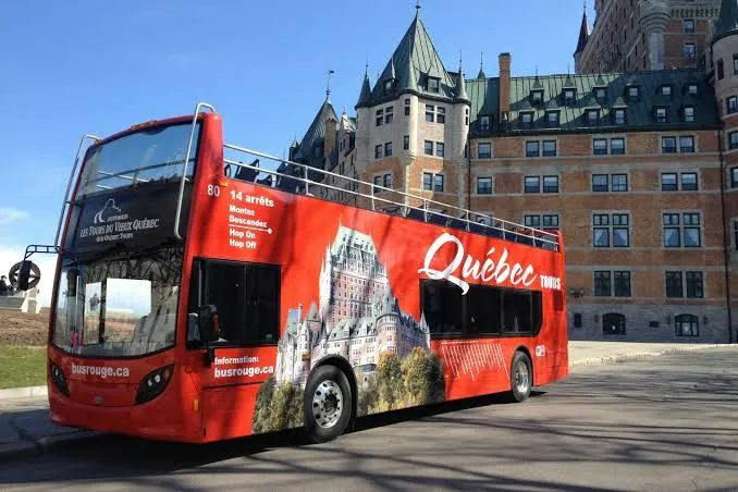 Hop-on hop-off sightseeing bus moving through historic Quebec City