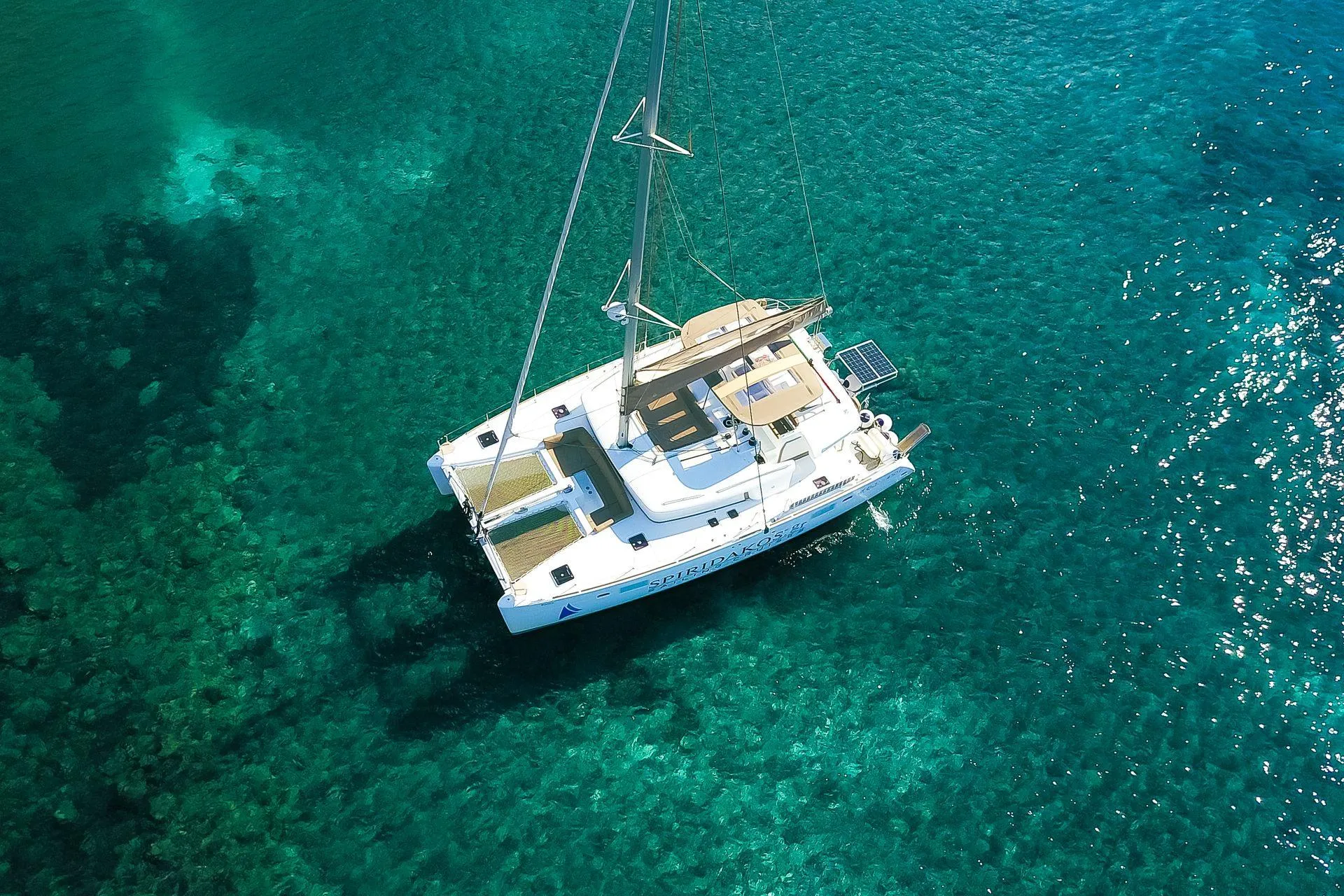 Aerial view of a catamaran navigating the Santorini caldera
