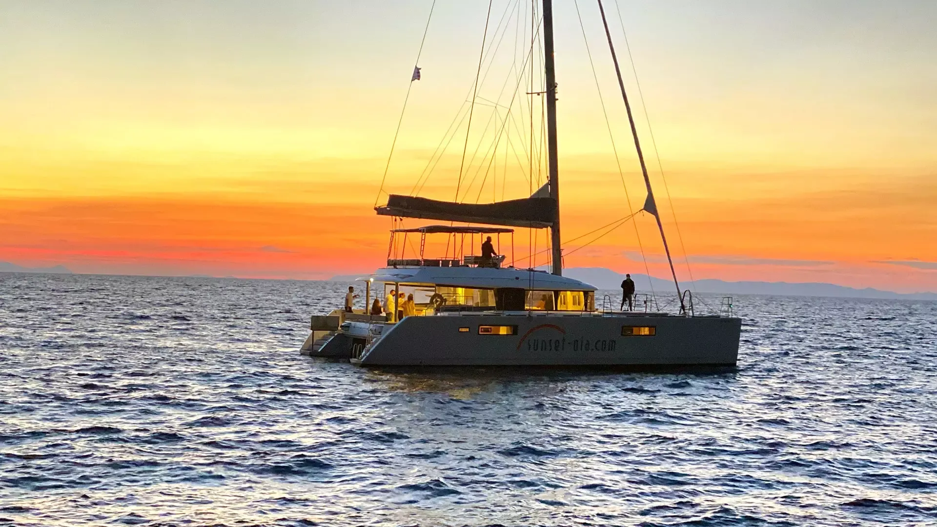 Catamaran at sea during Santorini sunset
