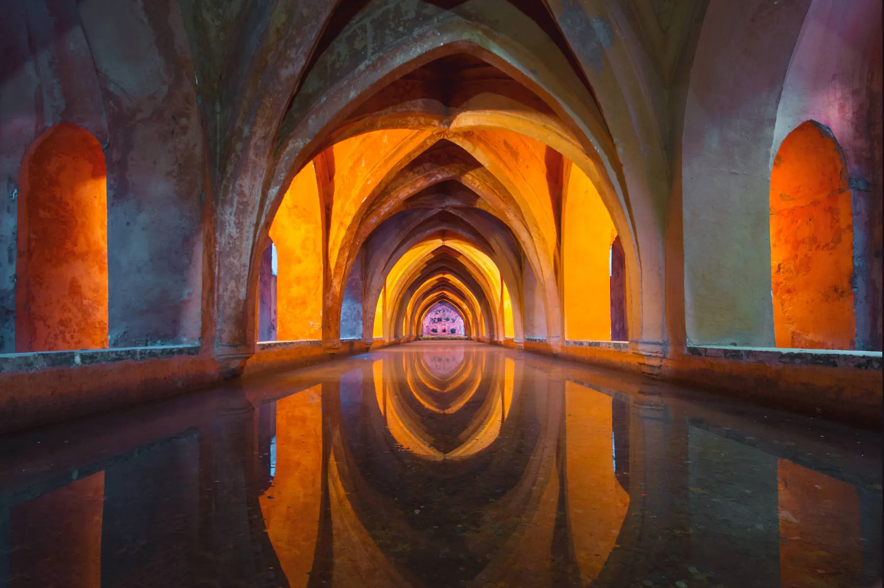 Historic baths area with pointed arches and soft illumination